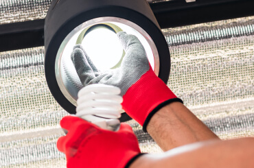 Electrician changing lightbulb in ceiling can ligh